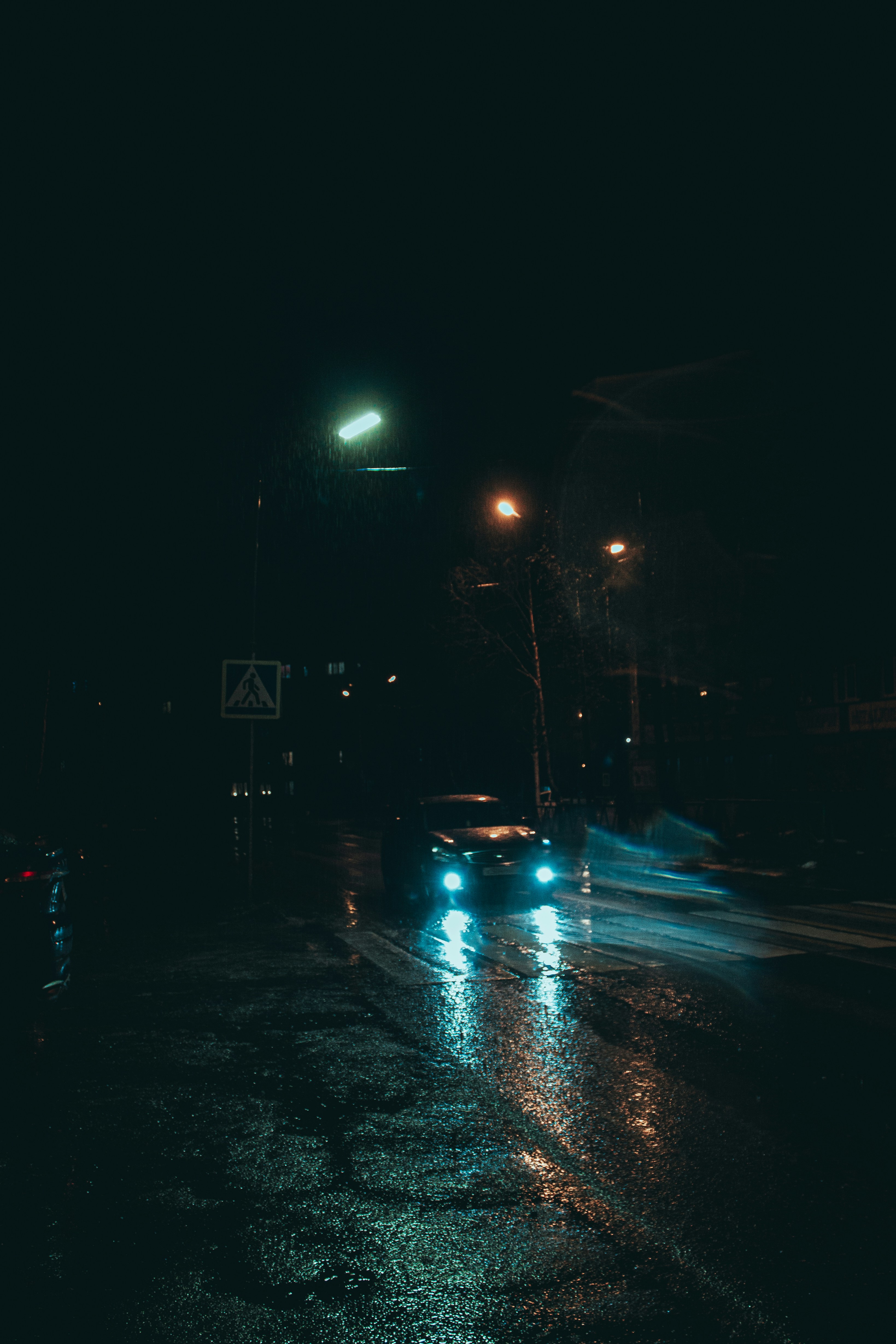 Wet night street with headlights and low visibility