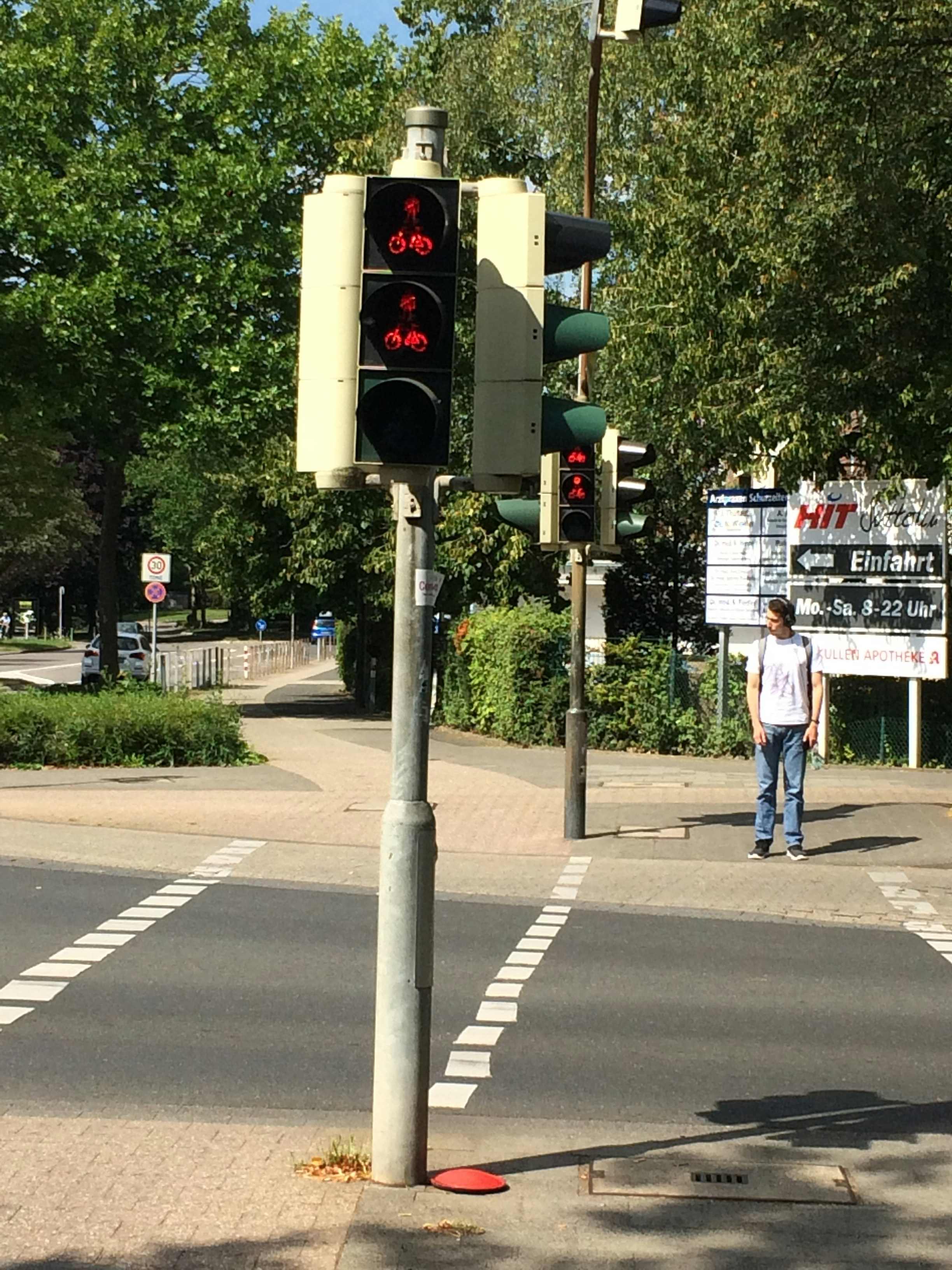 Pedestrian waiting near traffic signals at an intersection